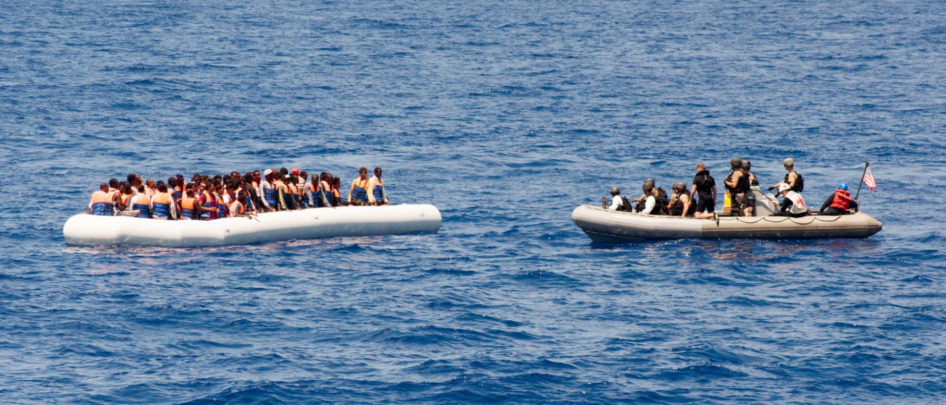 Sailors assigned to USS Carney (DDG 64) approach a small craft full of migrants while on patrol in the Mediterranean Sea July 29, 2016