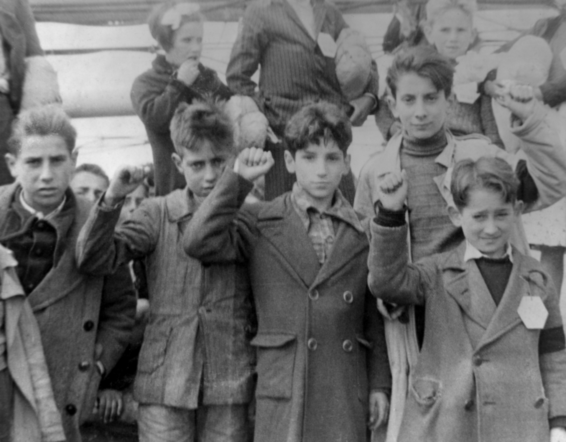 Children preparing for evacuation from Spain, during the Spanish Civil War, some giving the Republican salute. Source: Wikimedia Commons, CC BY-SA 3.0.