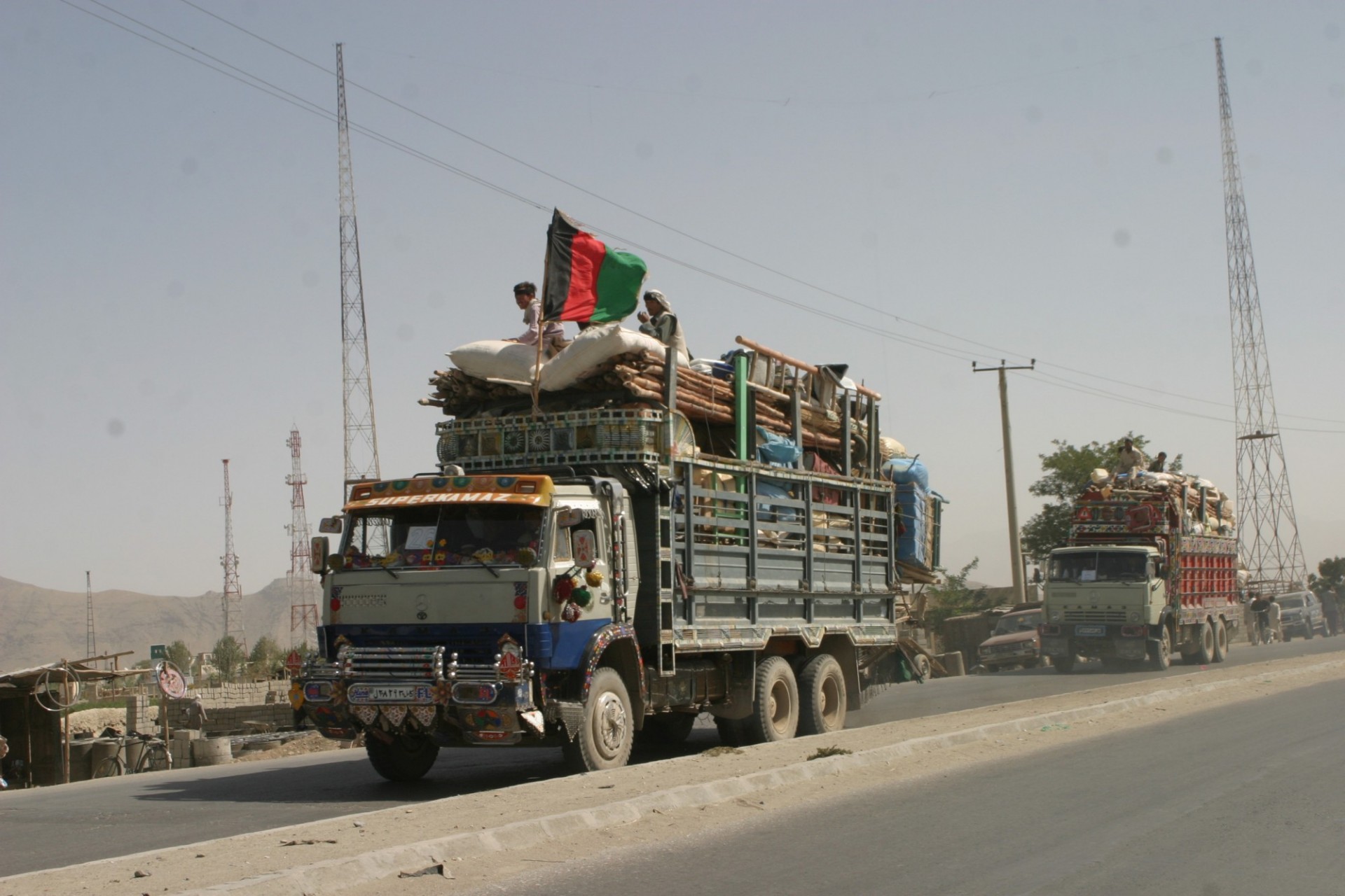 A truck loaded with Afghan refugees returning from Pakistan after years in exile pulls into the UN reception center in Kabul. Source: USAID, Wikimedia Commons, Public domain.