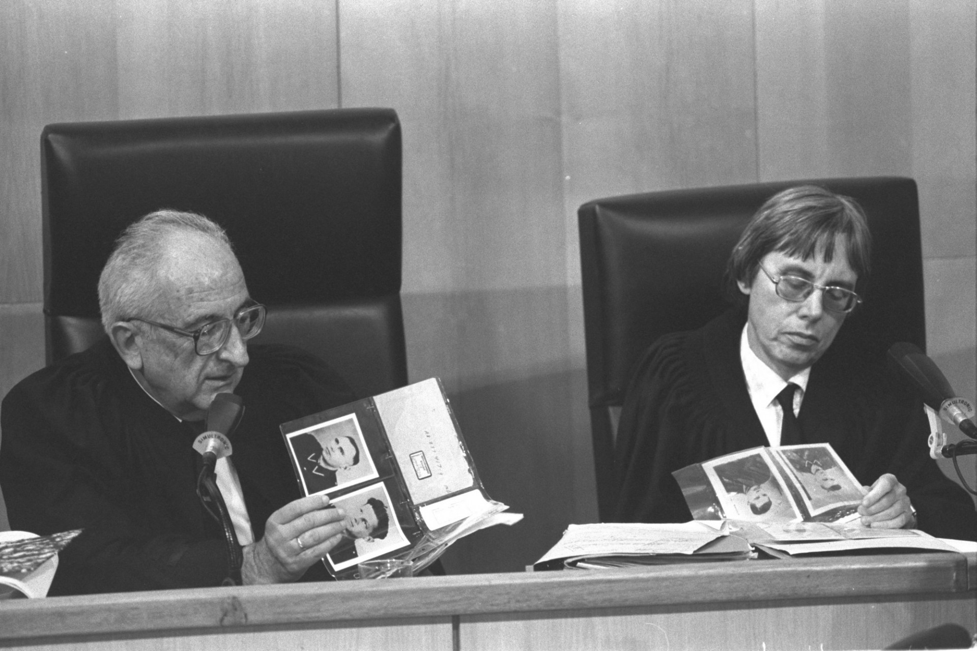 Supreme Court Justice Dov Levin and District Court Judge Dalia Dorner look at a photo album during the trial of John (Ivan) Demjanjuk in Jerusalem (23/02/1987). Source: Government Press Office, on Flickr. CC BY-SA 3.0.
