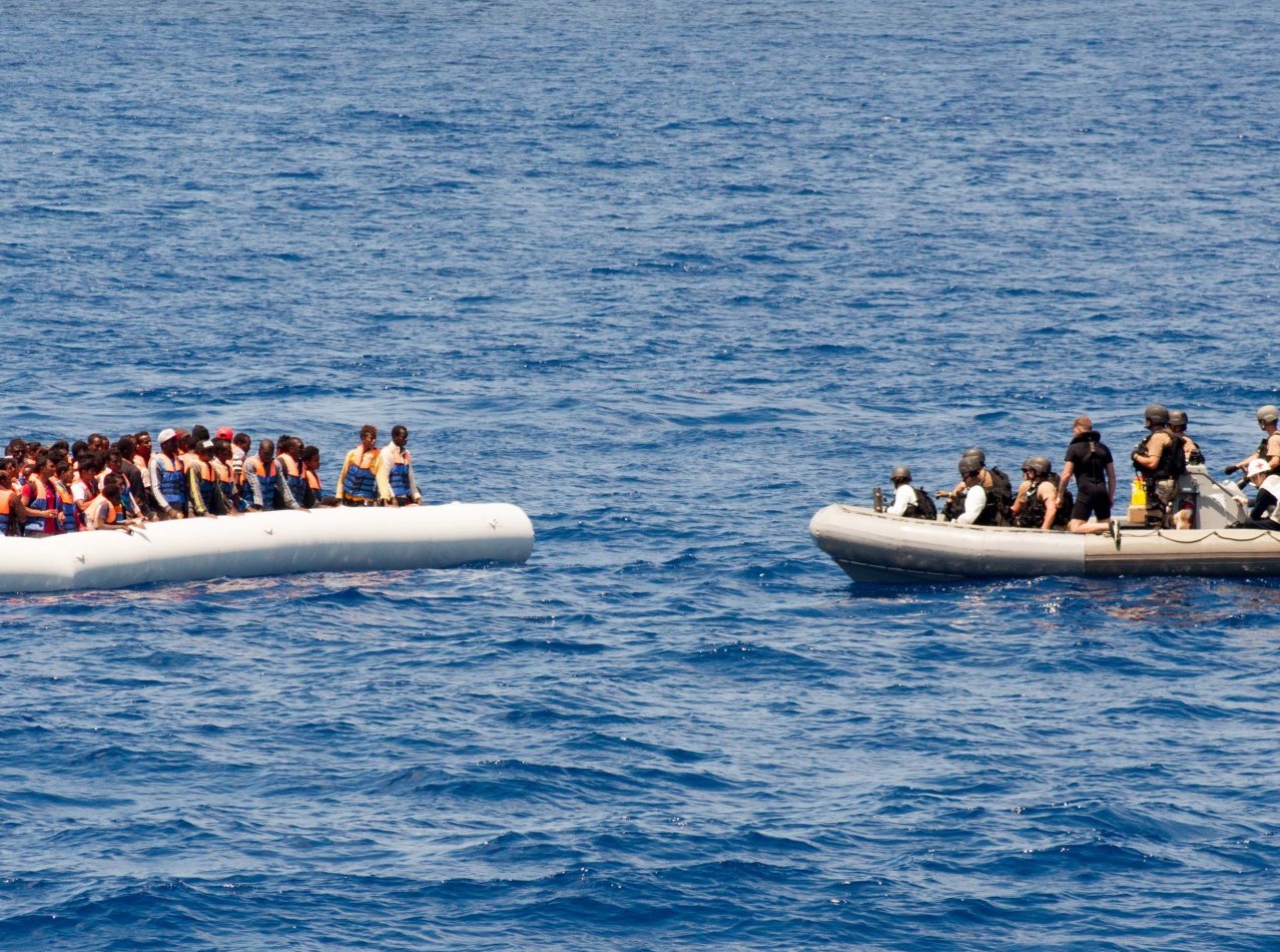 Sailors approach a small craft full of migrants while on patrol in the Mediterranean Sea. Source: Commander, U.S. Naval Forces Europe, Flickr, Public Domain