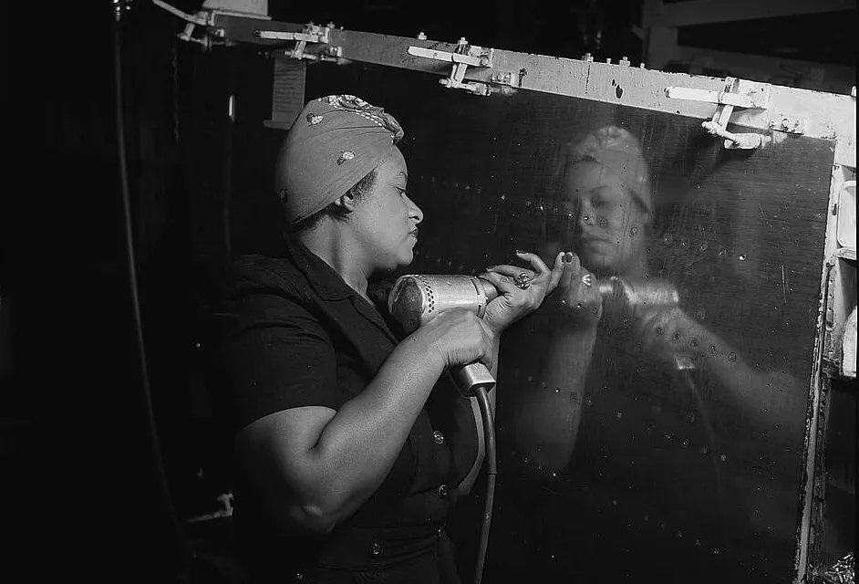 Operating a hand drill at Vultee-Nashville, woman is working on a "Vengeance" dive bomber, 1943