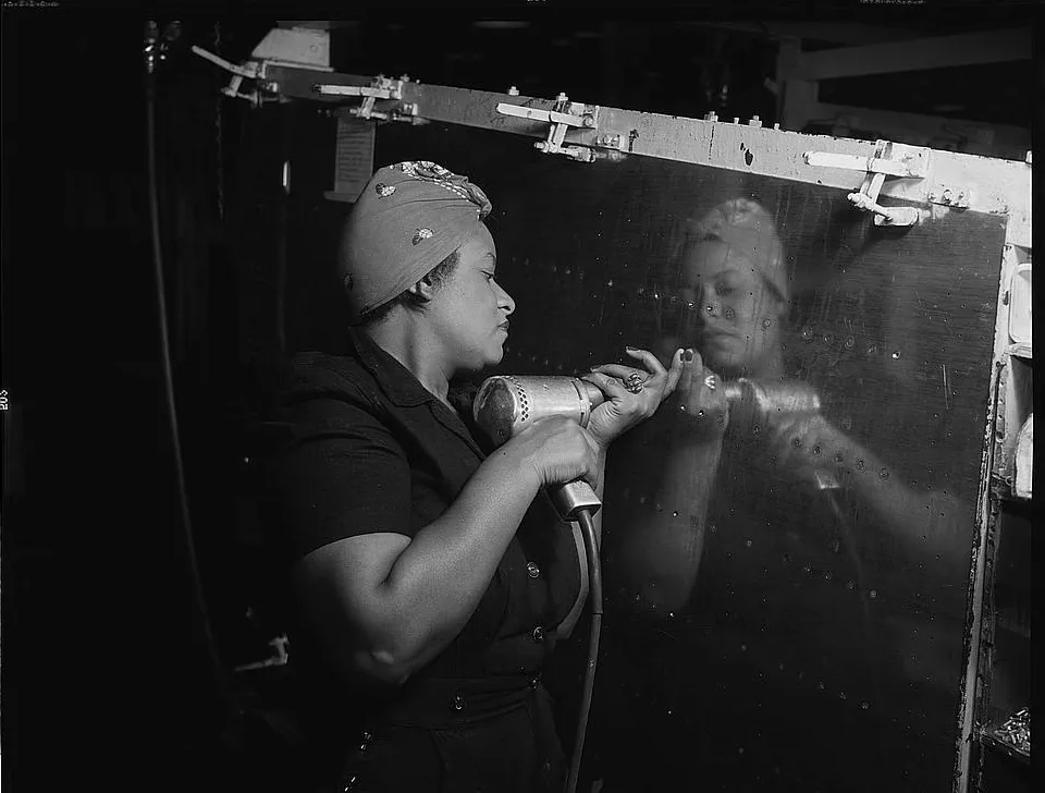 Operating a hand drill at Vultee-Nashville, woman is working on a "Vengeance" dive bomber, 1943