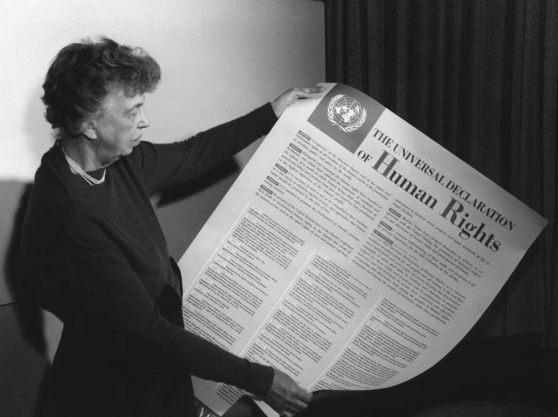 Eleanor Roosevelt holding poster of the Universal Declaration of Human Rights (in English), Lake Success, New York. November 1949.