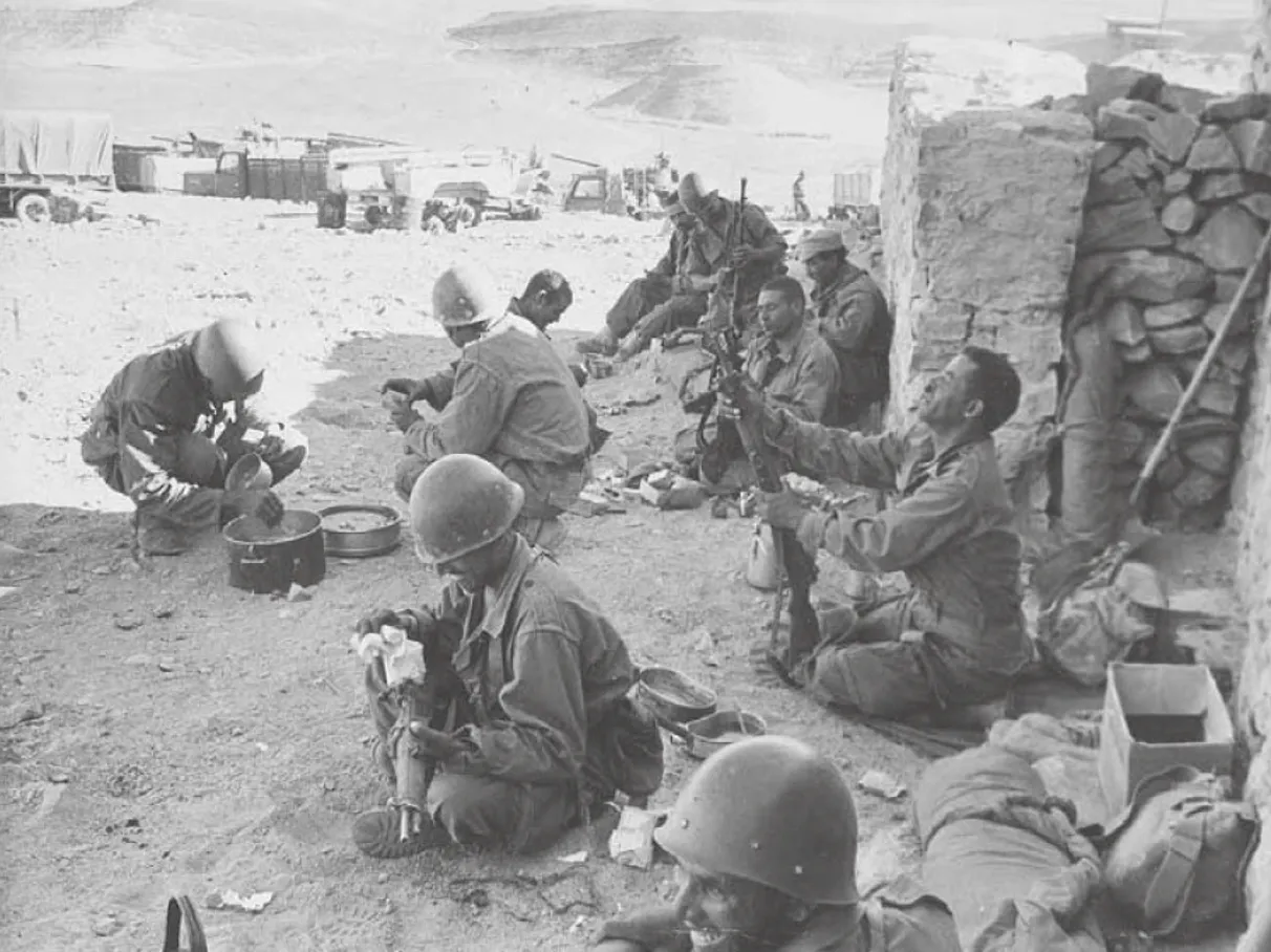 Moroccan soldiers sit in the shade cleaning their weapons and preparing food during a lull in border fighting against Algerian troops, near Tindouf in southwestern Algeria, November 4, 1963. (AP/Wide World Photos) (Source: Student dissertation)